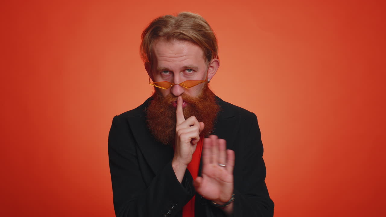 젊은이가 손가락을 입술에  ⁇ 러 침 ⁇ 을 지시합니다. 신호는 비밀을 말하지 않습니다.