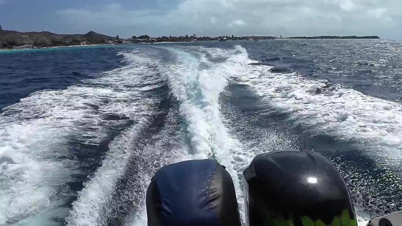 Pemandangan buritan ombak speedboat cepat di laut Karibia yang biru