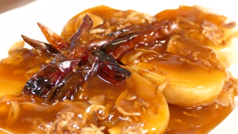 close-up footage of son in law egg , deep fried egg with sweet and sour tamarind sauce, topping with dried chilli, thai famous dish