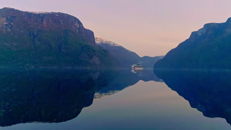 Luftaufnahme-Des-Luxuskreuzerschiffes-Auf-Dem-Ruhigen-Fjord-Während-Der-Blauen-Stunde-Am-Morgen