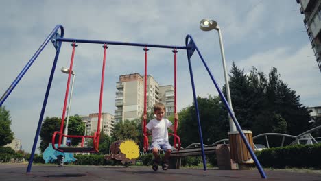 un niño se balancea en un columpio en la ciudad 02