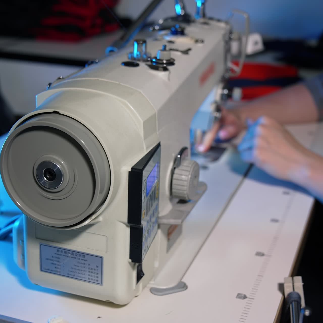 Female in clothing manufactory. Female hands working in clothing factory