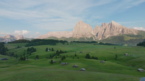 slow dolly across green hills at alpe di siusi with dolomites backdrop during golden hour