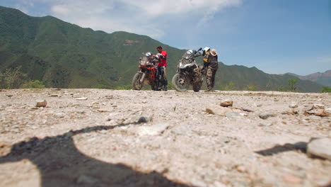 aerial of motorcycle riders riding motorbike on mountain roads