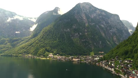 Aerial view of Hallstatt, Austria, captured by drone, showcasing its picturesque lakeside homes, majestic mountains, and the unique charm of this enchanting alpine village.