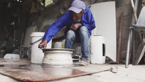 old african handyman making an object