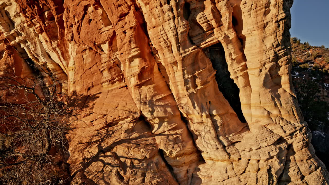 Stunning aerial footage of a remote natural arch as the rising sun casts a warm glow near Kanab, Utah.