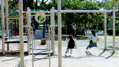 kids enjoying swings and slide in park