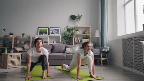 pareja practicando yoga en casa