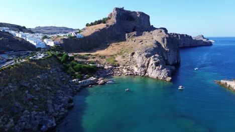 agios pavlos beach in rhodes, greece with acropolis of lindos, houses and mediterranean sea during the day filmed with the drone