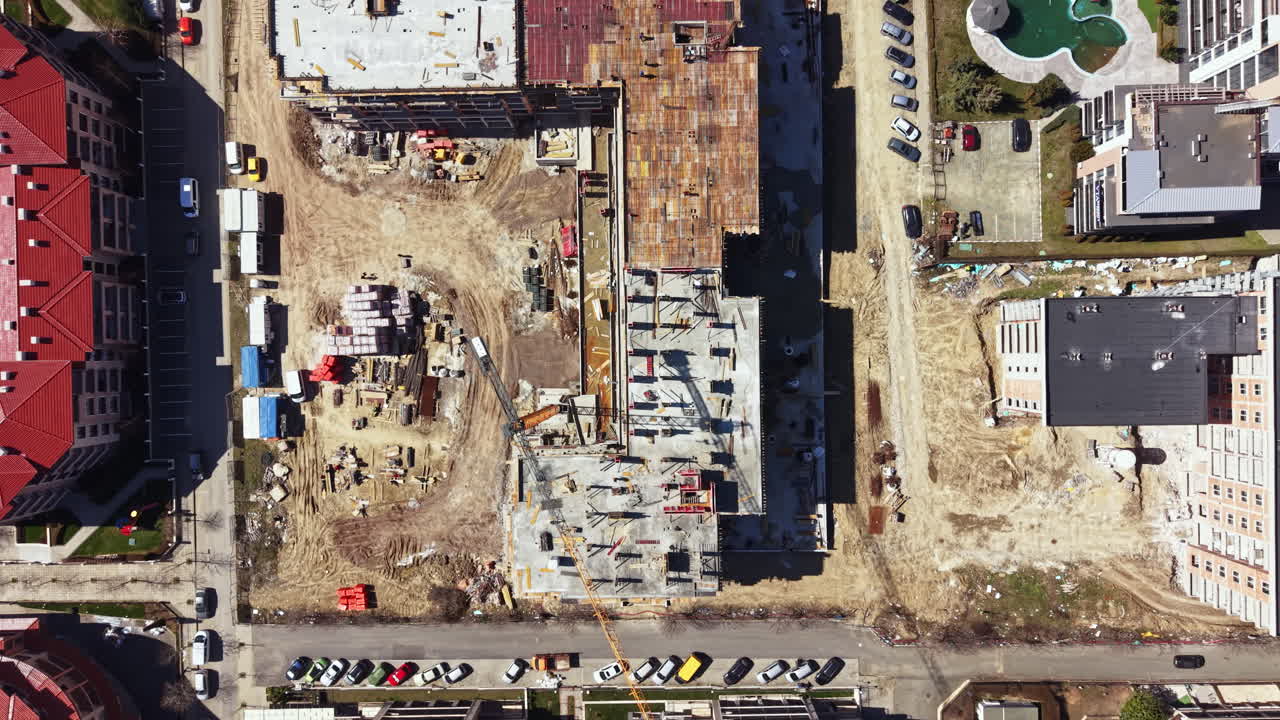 Costruzione di un nuovo edificio con una disposizione del cantiere e attrezzature visibili in un'area urbana durante le ore diurne