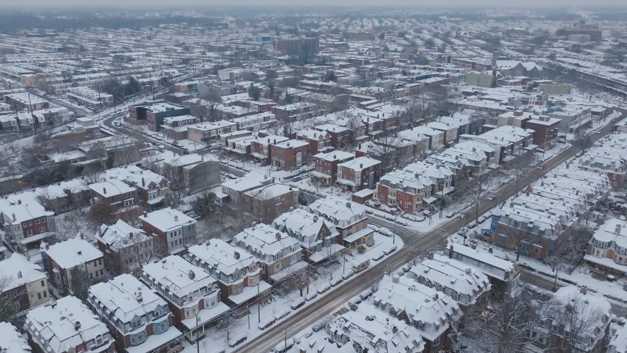 Aerial flyover of historic row homes in snow covered neighborhoods in West Philadelphia, Pennsylvania.