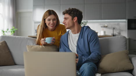 happy lovers calling laptop drinking coffee at home. family talking computer