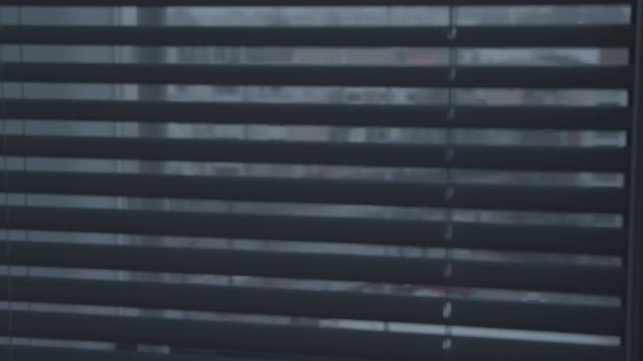 Opening and closing interior window blinds on a cold rainy day