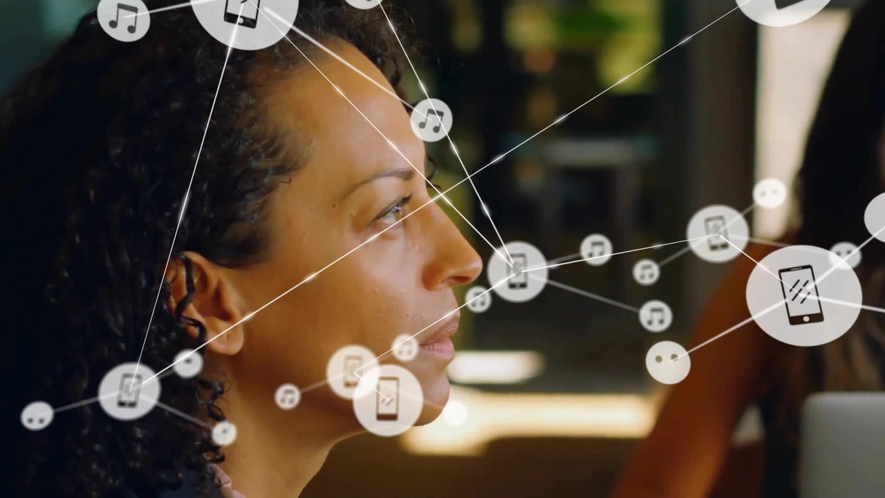 Animation of connected music and phone icons, african american businesswoman listening in meeting