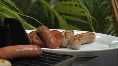 Barbacoa-Día-Soleado-Salchichas-Comida-A-La-Parrilla-Hombres-Colocando-Salchichas-En-El-Fuego-De-La-Barbacoa-Placa-De-Cocción-Cruda-Comida-Lista