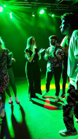 people dancing at a vibrant party with colorful club lighting