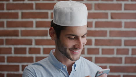 portrait attractive young muslim man student using smartphone texting browsing messages on mobile phone smiling happy enjoying cellphone communication slow motion