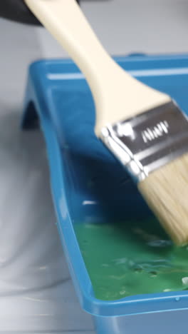 painting with a brush in a paint tray