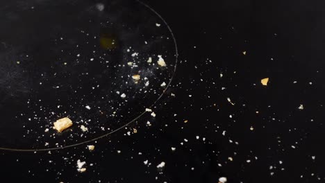 bread crumbs on a black countertop