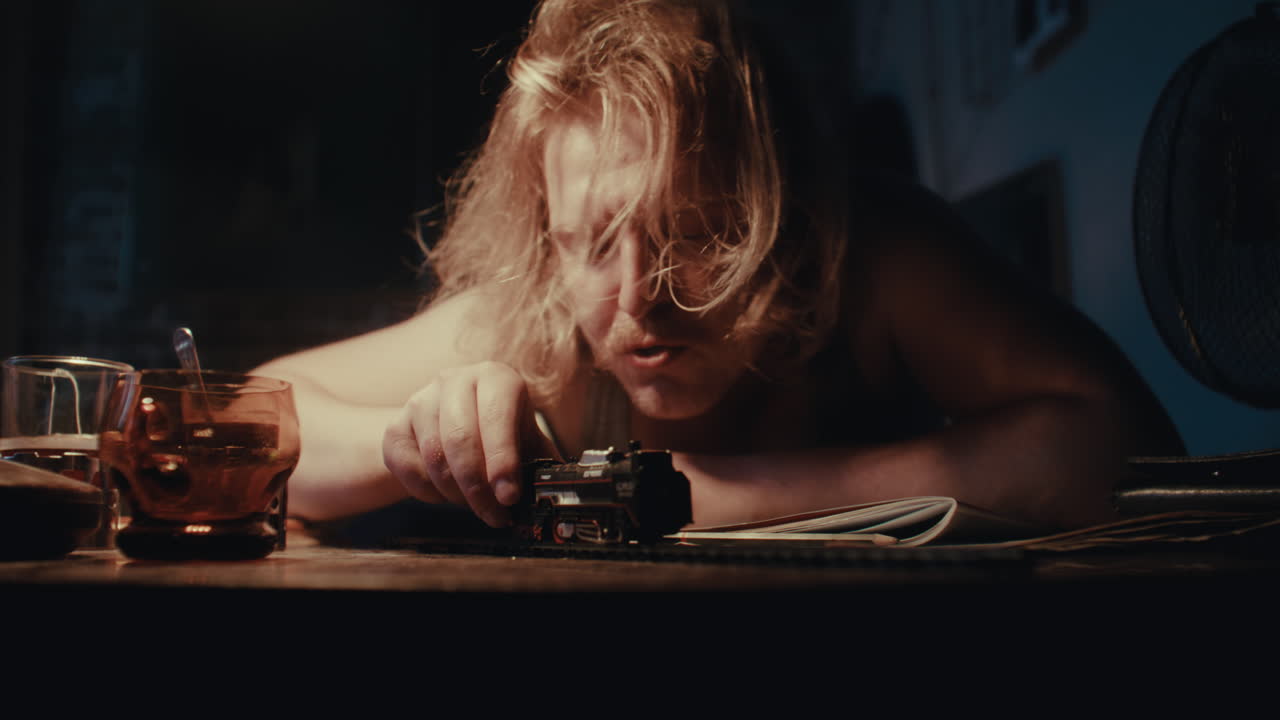 Man Playing With a Toy Train Late at Night