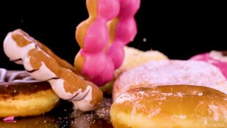 a twisted chocolate-glazed donut falls onto a pile of assorted donuts and pastries on a glossy surface, under bright studio lighting with a black background