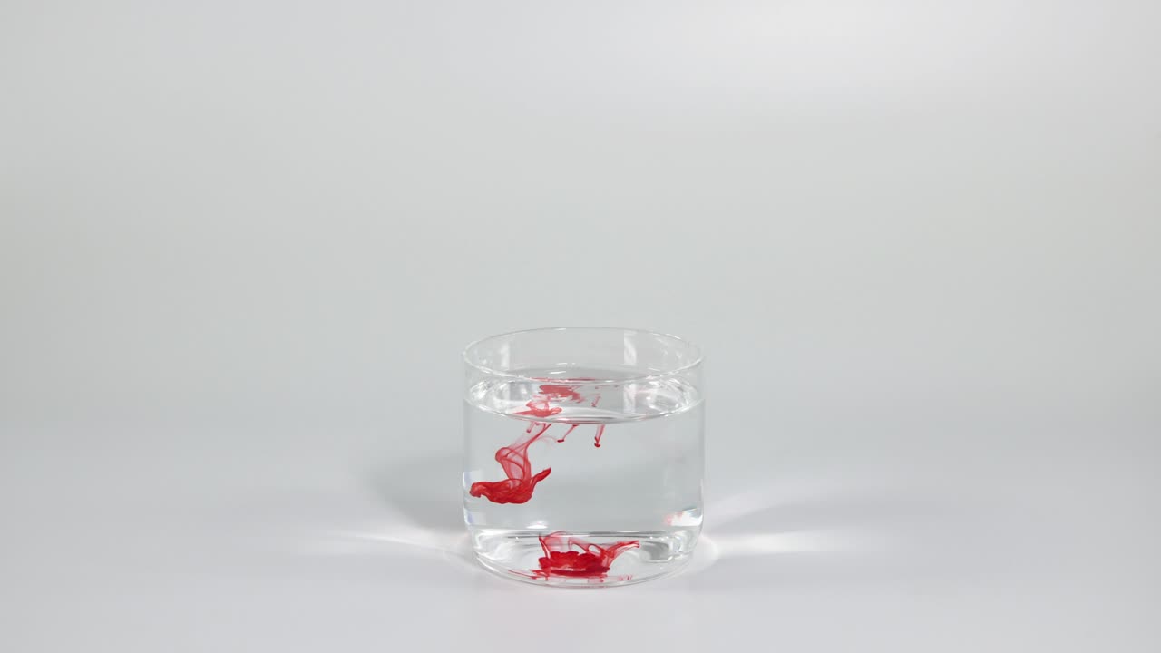 은 잉크가 은 물 잔에 천천히 퍼져나갑니다.
