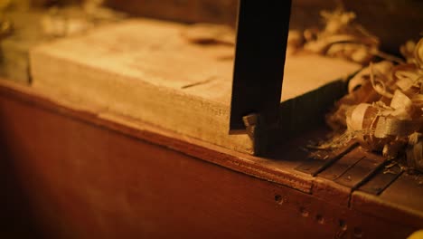 closeup of a carpenter cutting a woooden plank with a japanese saw, professional carpenter working at hhis workshop