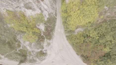 drone deportivo fpv volando a lo largo de un acantilado blanco. copter volando a través de un túnel natural estrecho en una fortaleza rocosa hace un bucle de energía