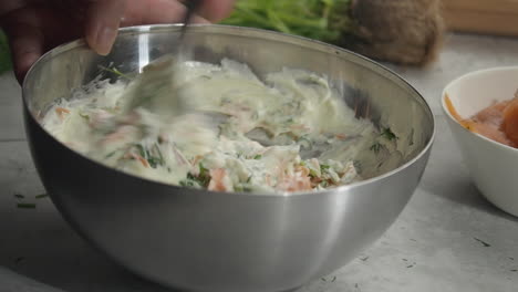 close up: chef mixes fresh smorgastarta ingredients in metal bowl