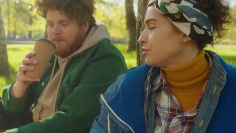 friends enjoying coffee together in a sunny park
