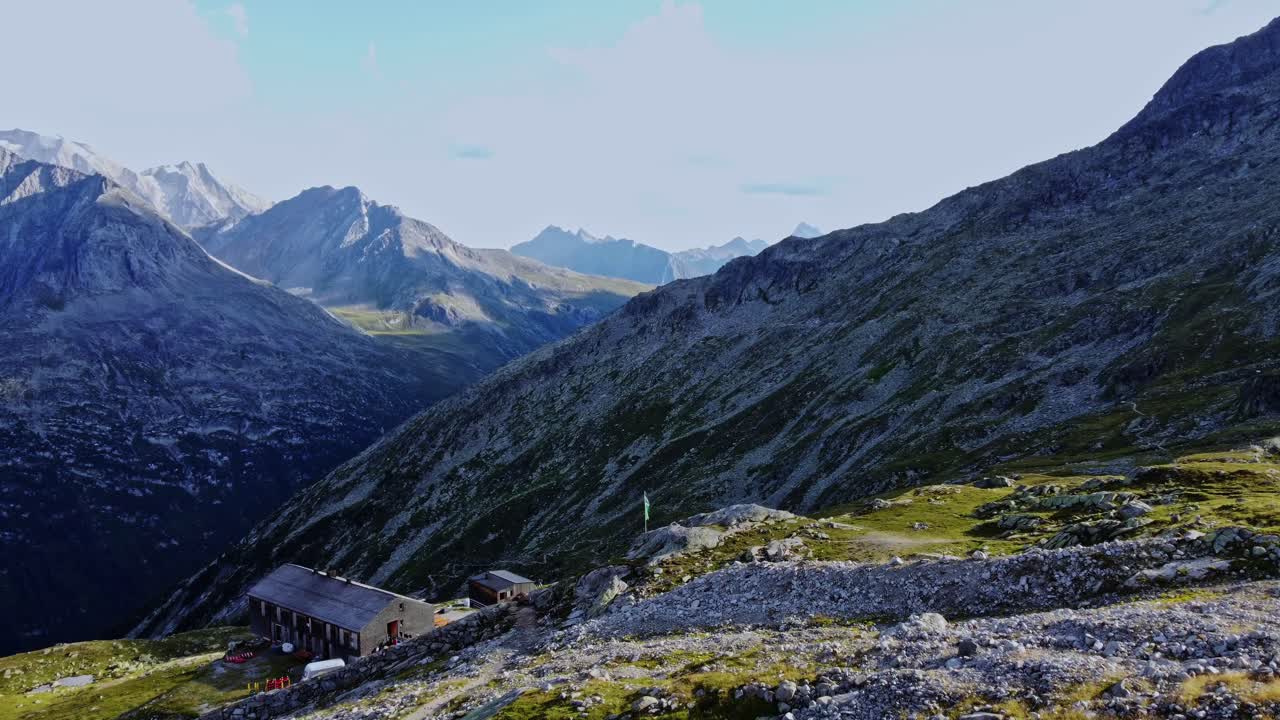 Fly-by drone shot beautiful scenic view of European hut named "Olpererh&uuml;tte" in Austrian Alps in summer with the Schlegeis Stausee below