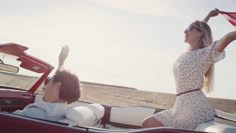 video of happy couple in a car with american flag