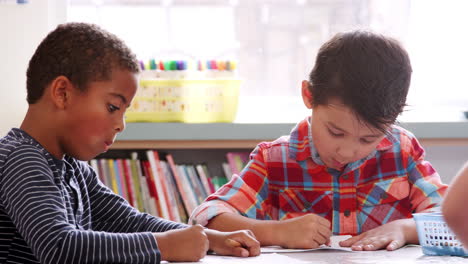 two elementary school schoolboys drawing in art class