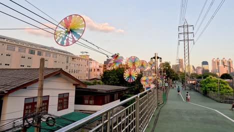 pinwheels spinning above a city walkway