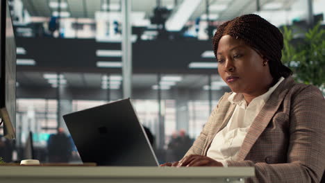 mujer trabajando en una computadora portátil en una oficina moderna
