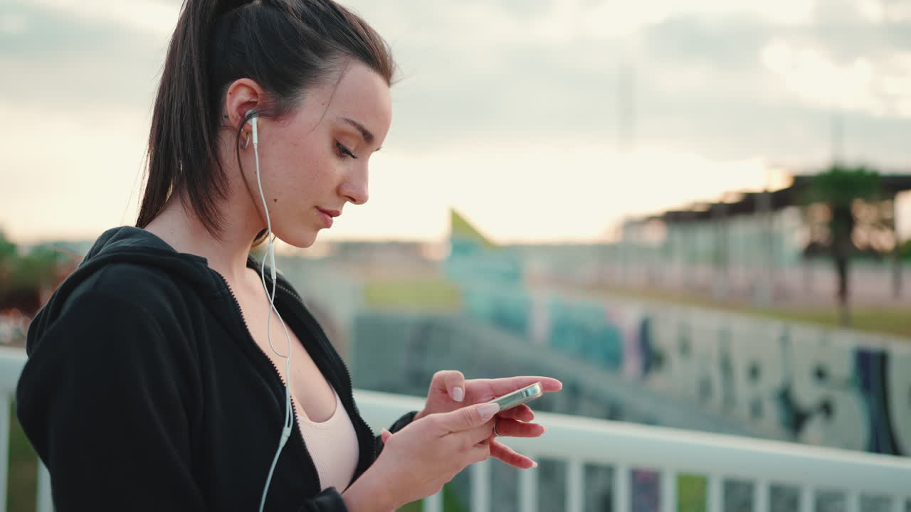Donna che usa il telefono mentre si allena all'aperto