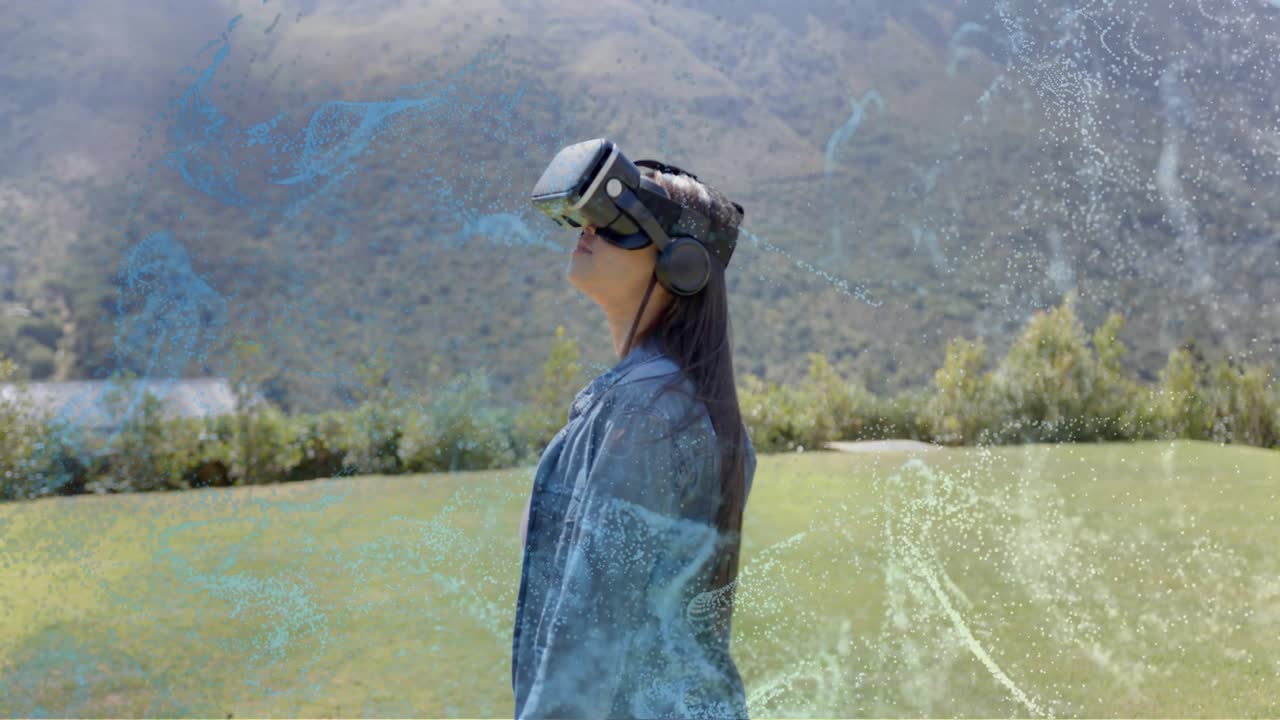 Teen using VR walking across lawn, pausing, looking up while blue overlays growing, exploring VR