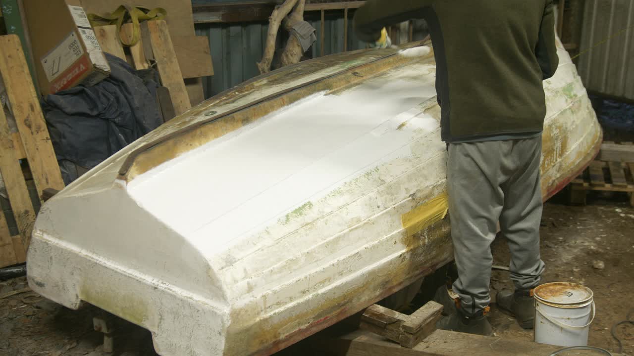 Verniciatura dello scafo di una barca in vetroresina con finitura in poliestere.