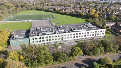 Orbital aerial view of Burnham Grammar School, with expansive green sports fields in the backdrop, Berkshire UK, October 2024