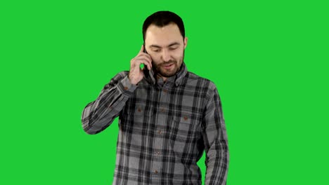 un hombre está hablando por teléfono y sonriendo en una pantalla verde, clave de croma