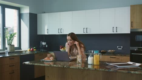 business woman having chat at computer in kitchen. smile person talking online.