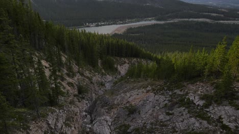 4K-Drohnenaufnahmen-Vom-Abtauchen-Eines-Steilen-Felshangs-In-Den-Kanadischen-Rocky-Mountains-Zwischen-Ausgedehnten-Lärchenwäldern