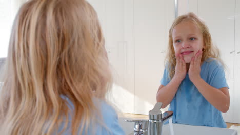 una niña lavándose la cara