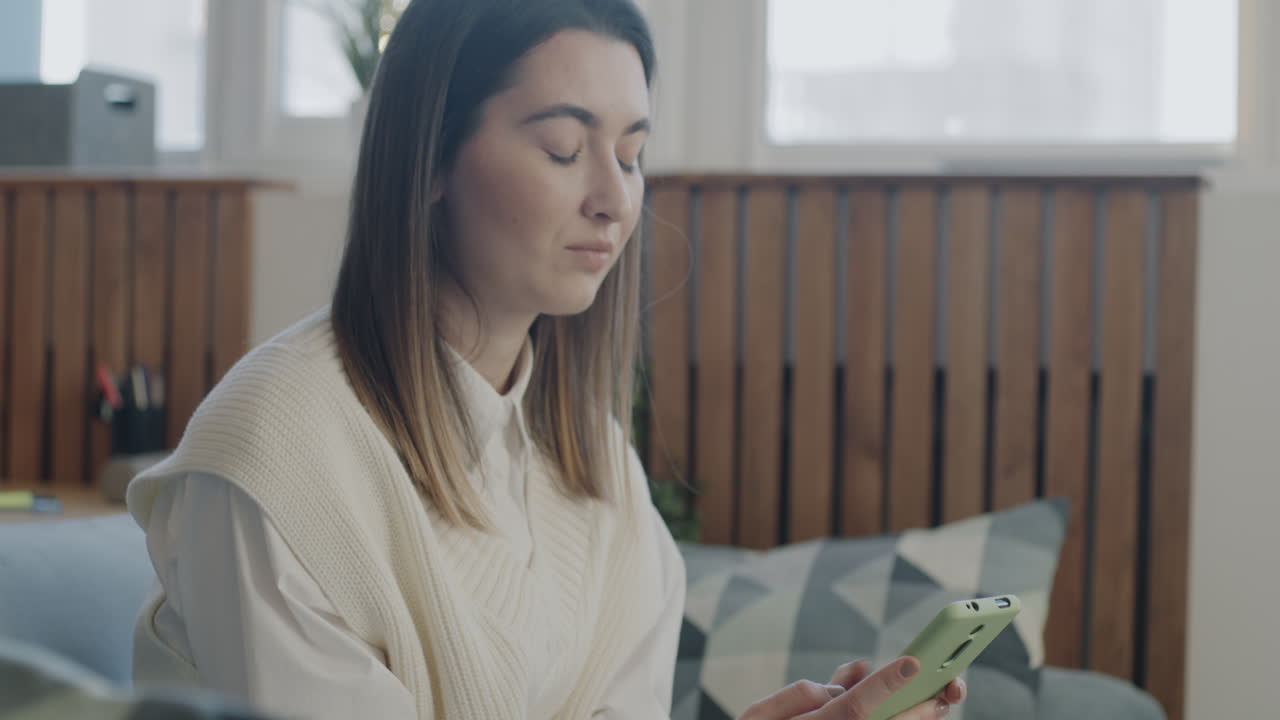 Donna che usa lo smartphone in un ufficio domestico