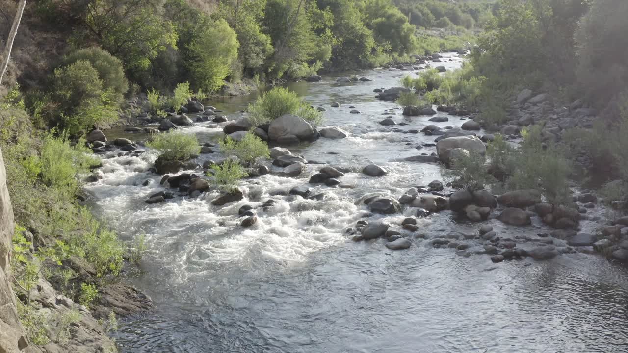 Un drone vola sopra un ruscello idilliaco in una zona montuosa