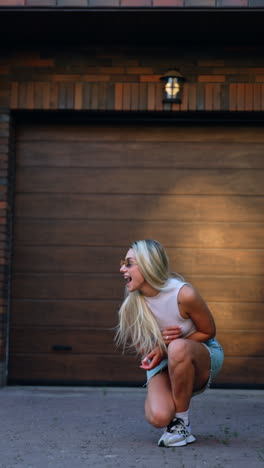 woman enjoying a sunny day outdoors. a young woman walks confidently in casual attire, enjoying a sunny afternoon near a wooden garage door