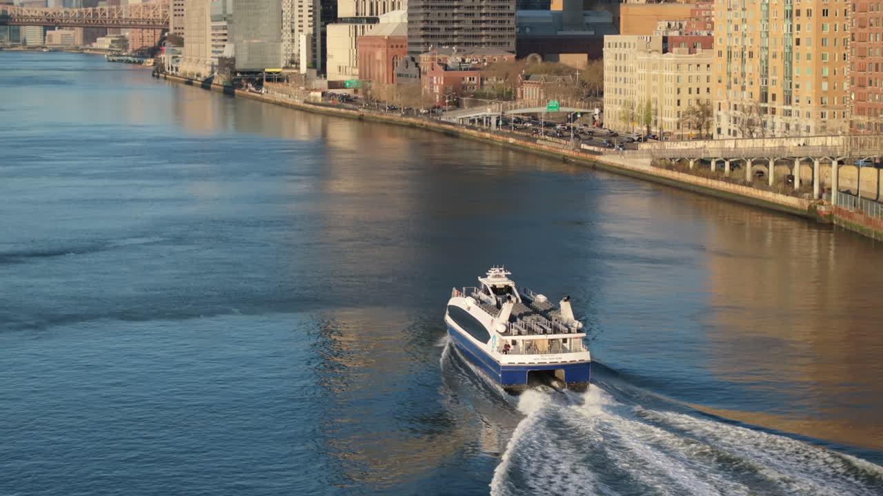 Aerial view of a ferry on New York City's East River. Shot at sunrise