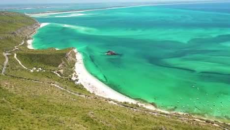 pan-up-drone-shot-revealing-an-beautiful-turquoise-waters-at-the-Arrabida-Portugal