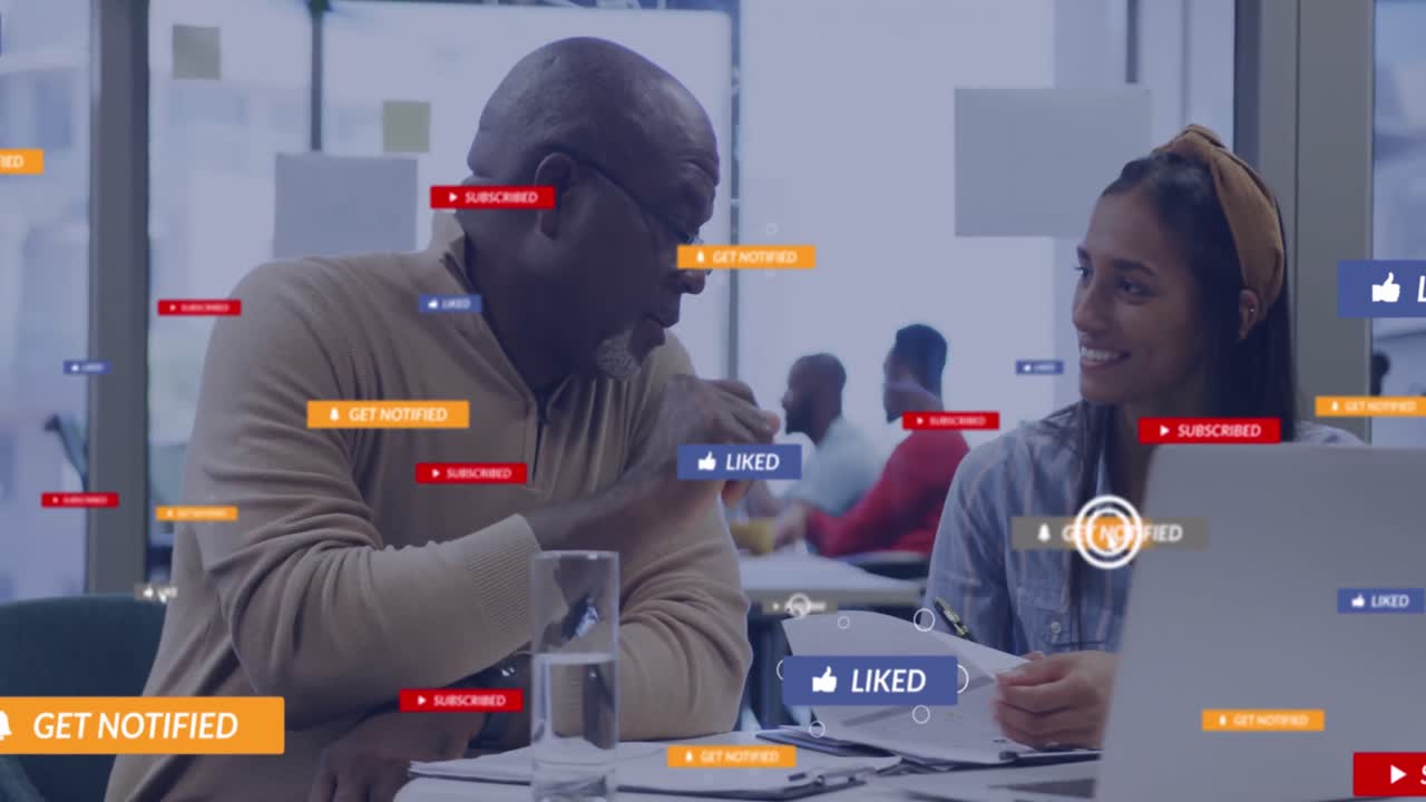 A group of diverse business colleagues talking and using laptops in an office